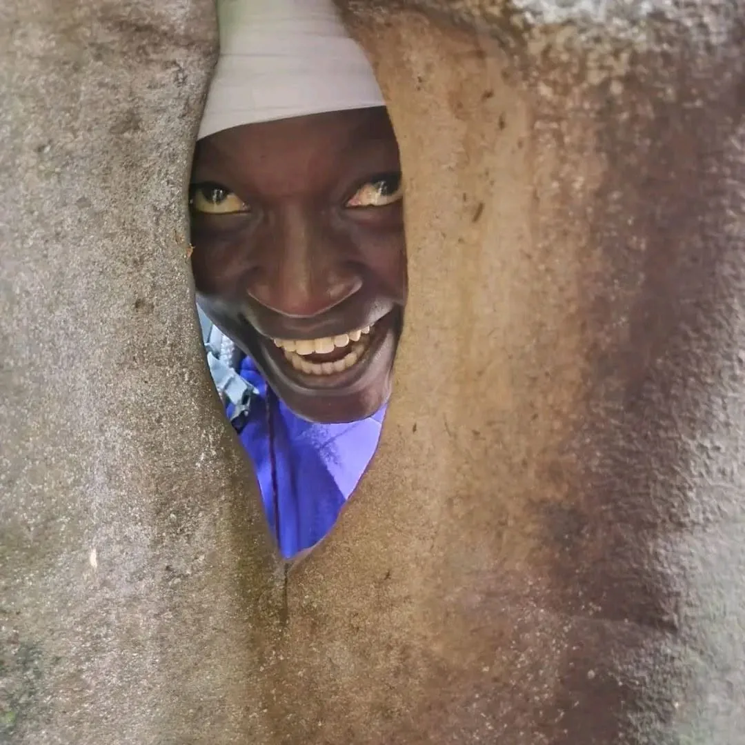 Smiling man framed through a narrow rock opening