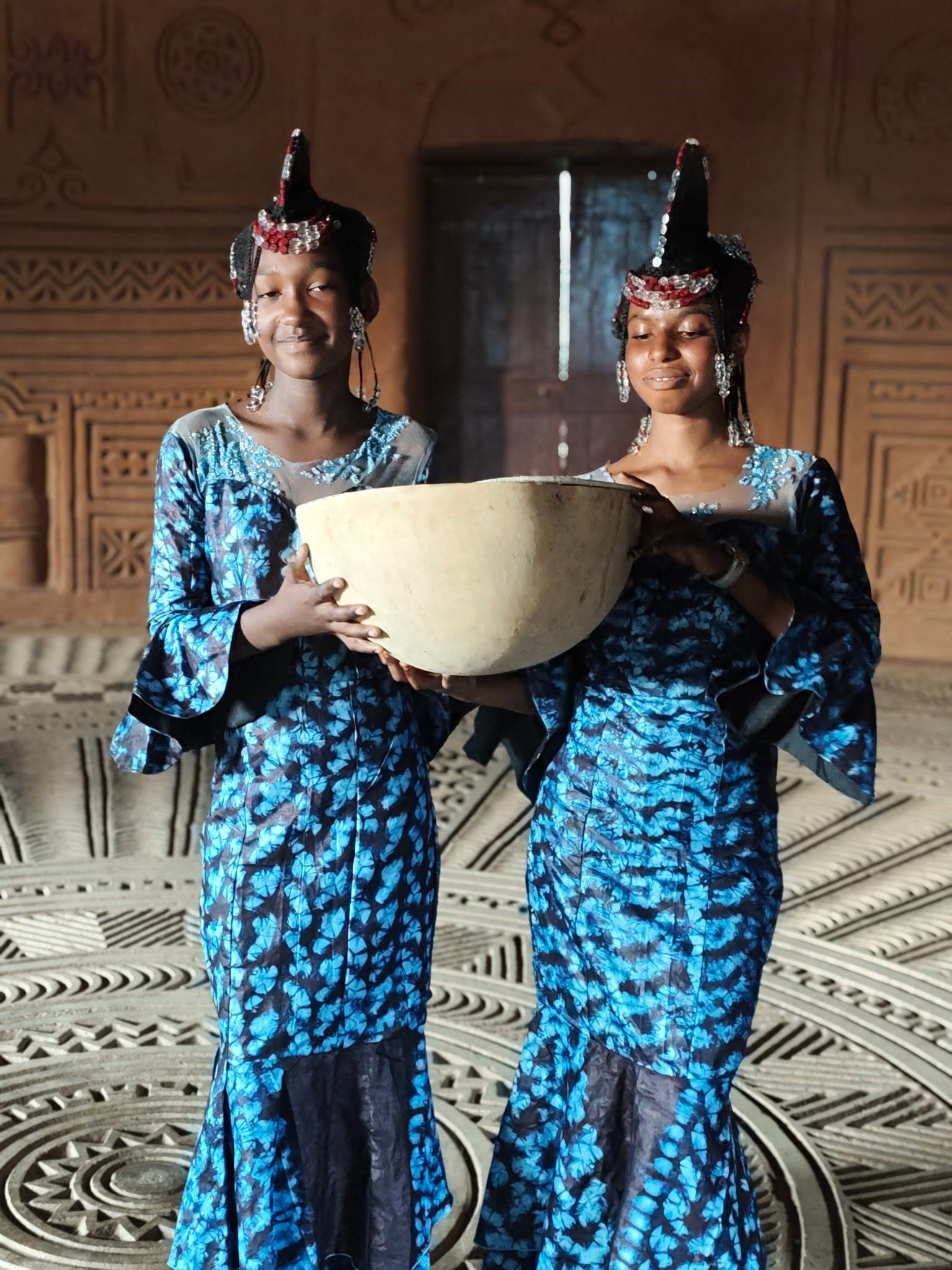 Girls with calabash bowls at a community gathering