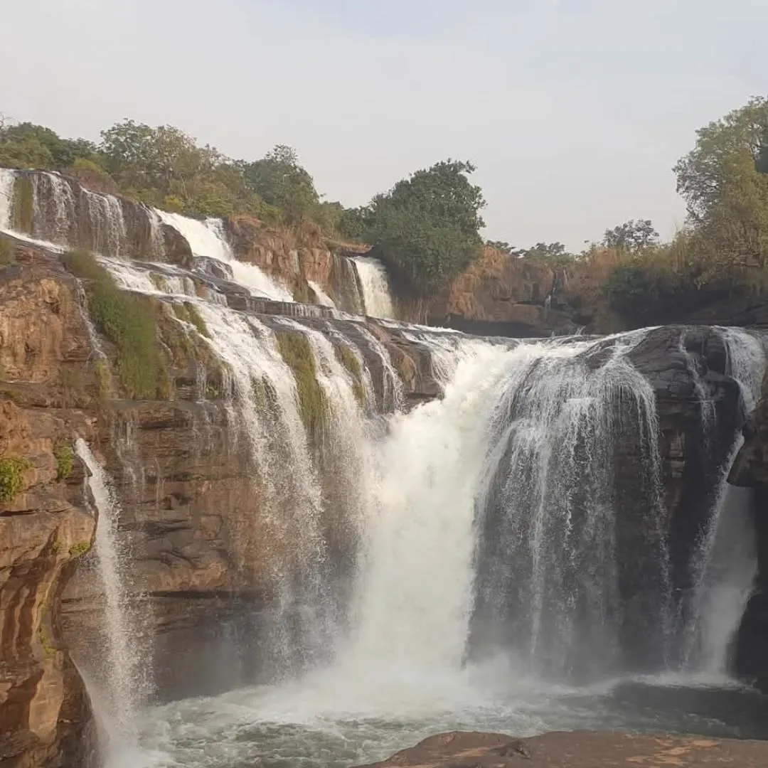 Wide multi-tier waterfall cascading over rock in the Guinean forest