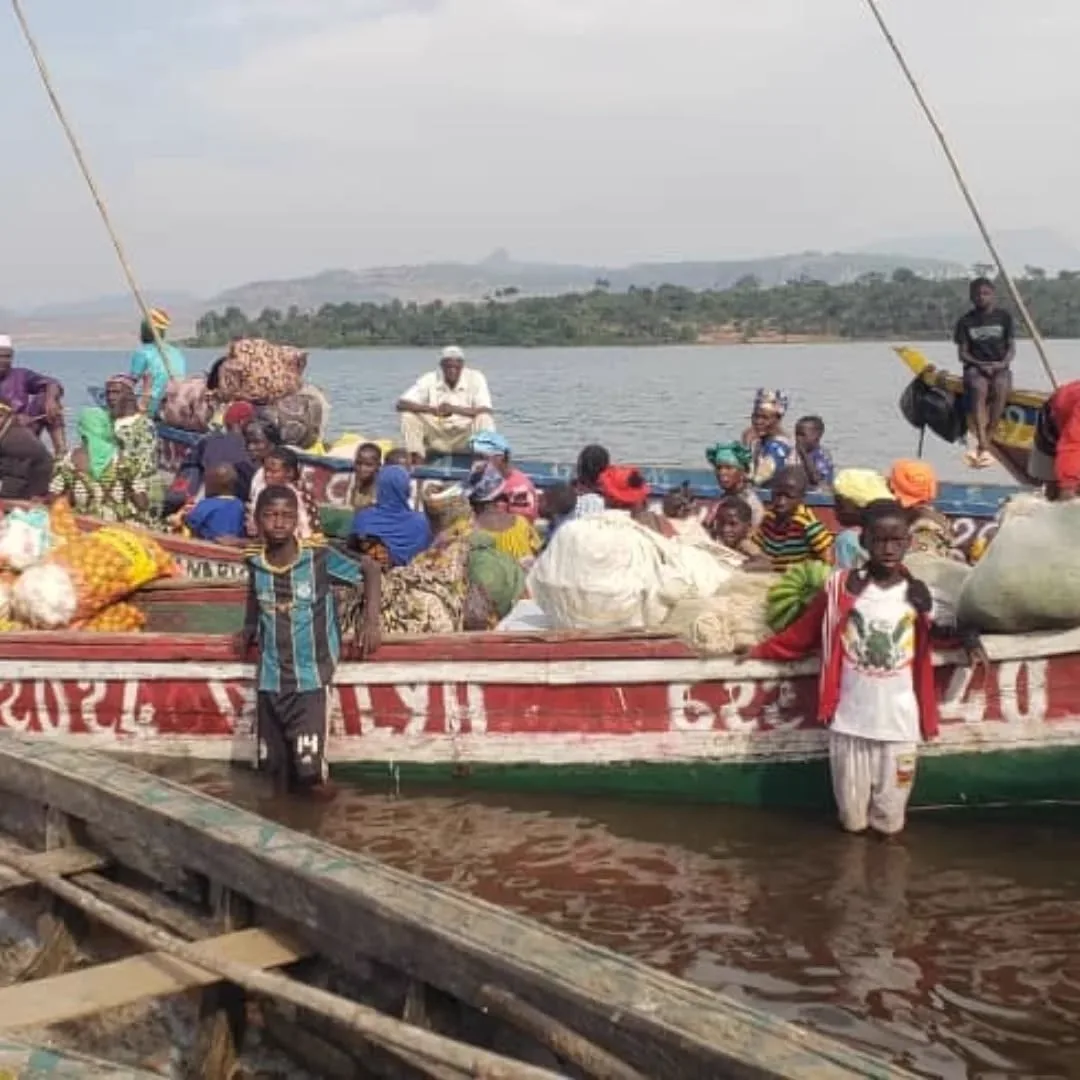 Traditional pirogue loaded with passengers and produce on a Guinean river