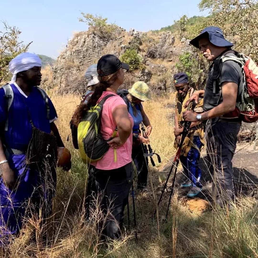 Trekking group pausing on a grassy trail in the Guinean highlands